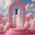 'Pink Arrogate' perfume bottle with silver cap on a pink platform against a cloudy sky background with Assaf branding