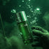 Green bottle labelled 'Attacks' with Assaf branding held by a gloved hand against a green underwater background.
