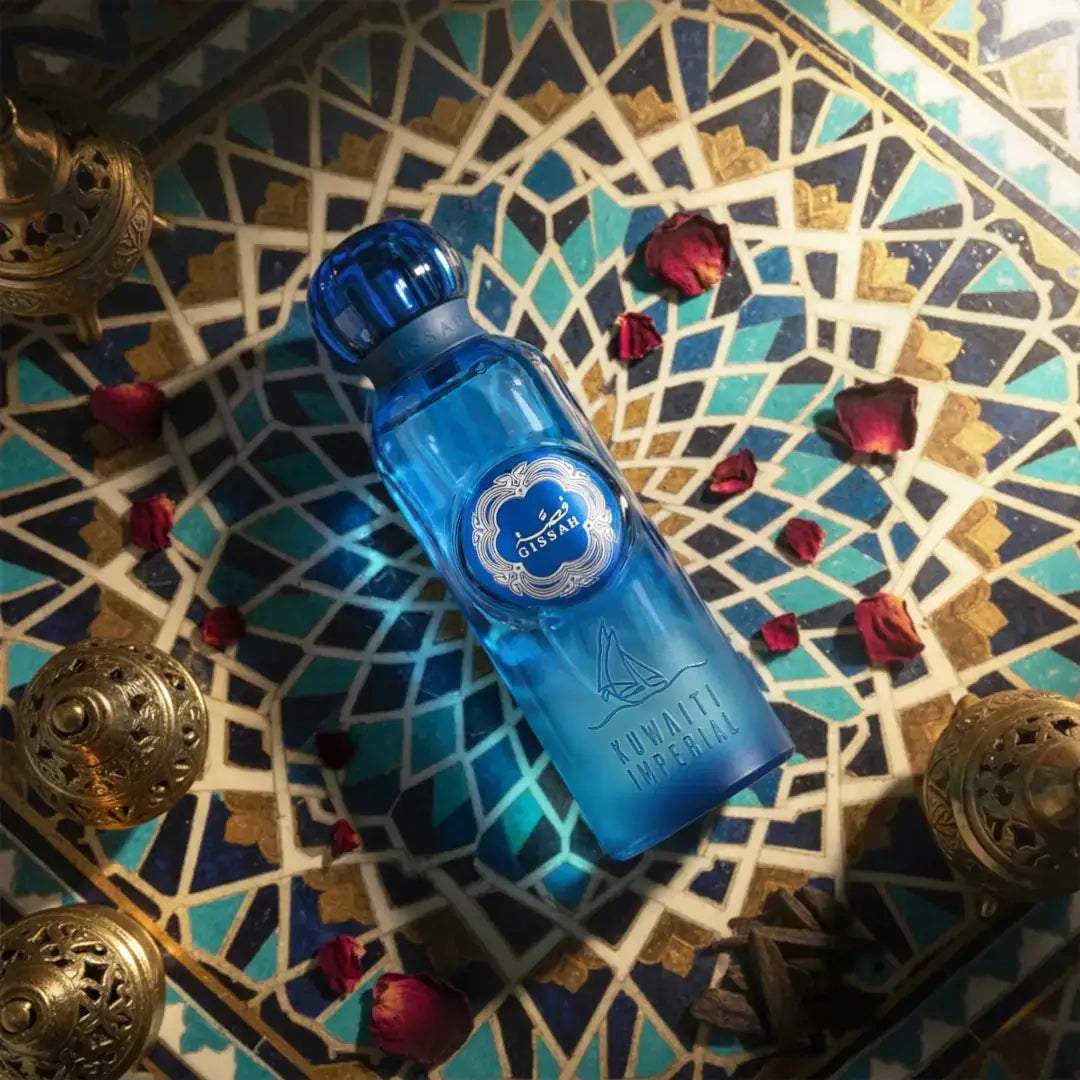Kuwaiti Imperial EDP Blue bottle with a decorative label on a patterned surface with red flowers and gold objects branded by Gissah