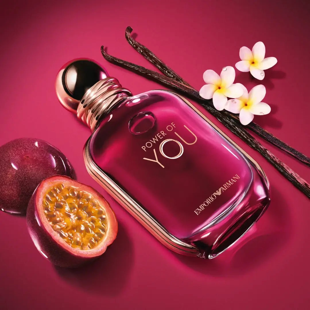 'Power of You' Emporio Armani perfume bottle with frangipani flowers, passion fruit and vanilla beans on a pink background