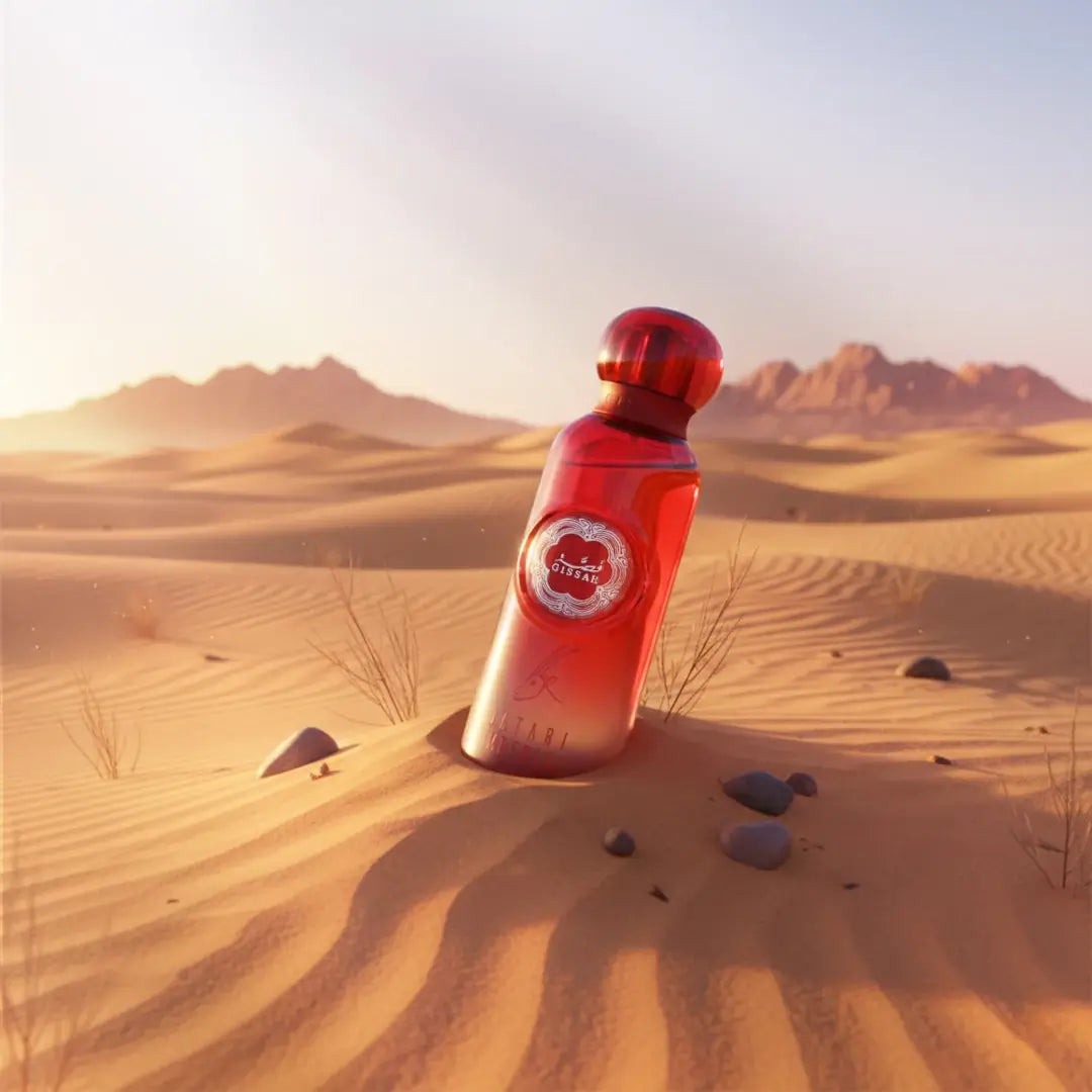 'Qatari Imperial' Red perfume bottle with a Gissah logo on sand dunes with mountains in the background