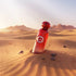'Qatari Imperial' Red perfume bottle with a Gissah logo on sand dunes with mountains in the background