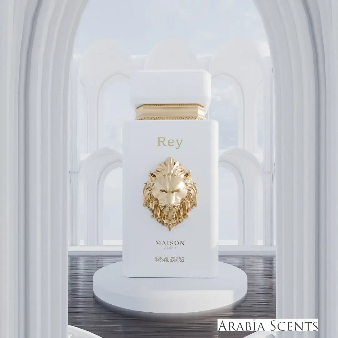Perfume bottle with gold lion emblem and 'Rey' text with Maison Asrar branding on a white pedestal against an architectural background featured by ArabiaScents