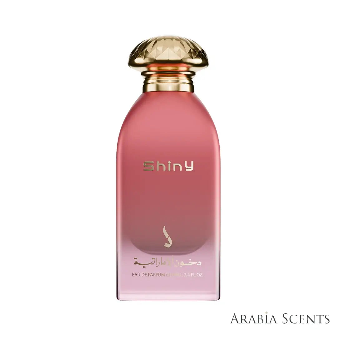 Pink perfume bottle with gold cap labeled 'Shiny' by Dkhoon Emirates featured by ArabiaScents on a white background