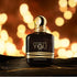 Perfume bottle labeled 'Stronger with You Oud' by Emporio Armani on a wooden surface with a warm, blurred background.