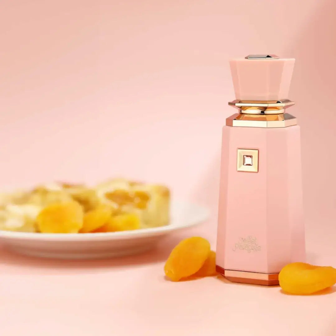 Sweet Paradise by French Avenue Pink perfume bottle with dried apricots on a pink background