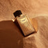 Dolce & Gabbana Velvet Desert Oud Ramadan Edition perfume bottle on a textured beige surface